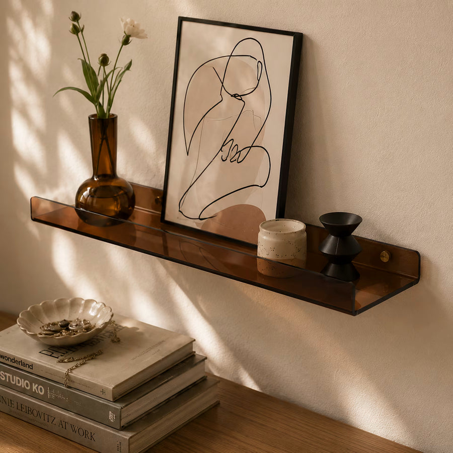 Brown transparent acrylic wall shelf styled with a vase, print and candle