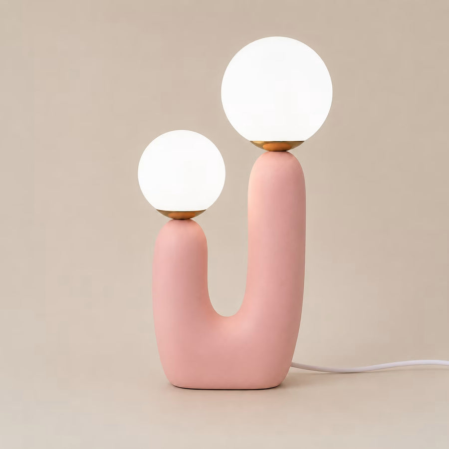 Side view of the 49cm powder-pink table lamp with a curved resin body