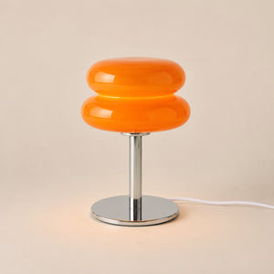 Orange glass statement table lamp glowing in a warm interior