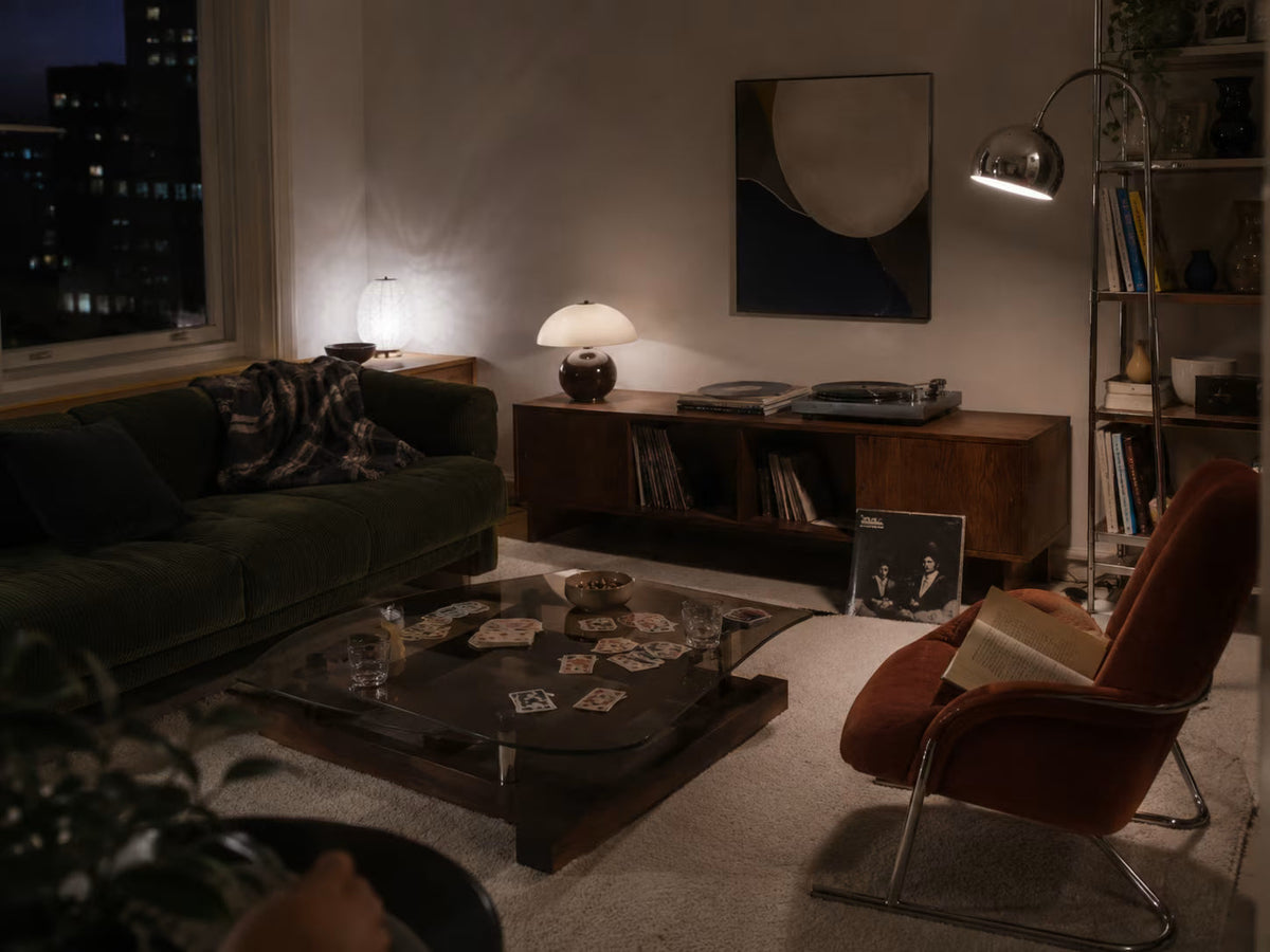 Screen-free living room with books, records and layered evening light