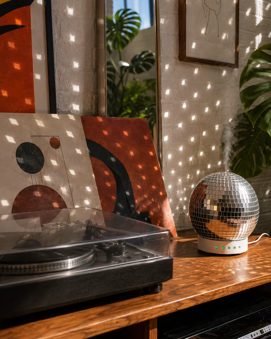 Rotating Disco Ball Diffuser casting mirrored reflections beside a record player