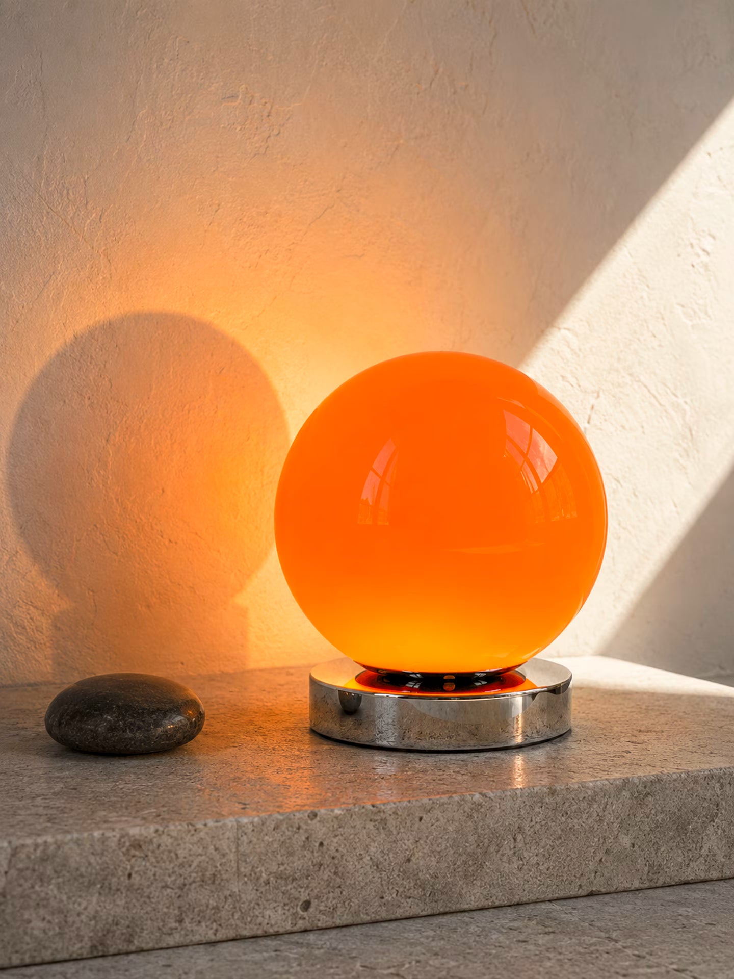 Nova Flare orange glass globe table lamp on a low chrome-finish base