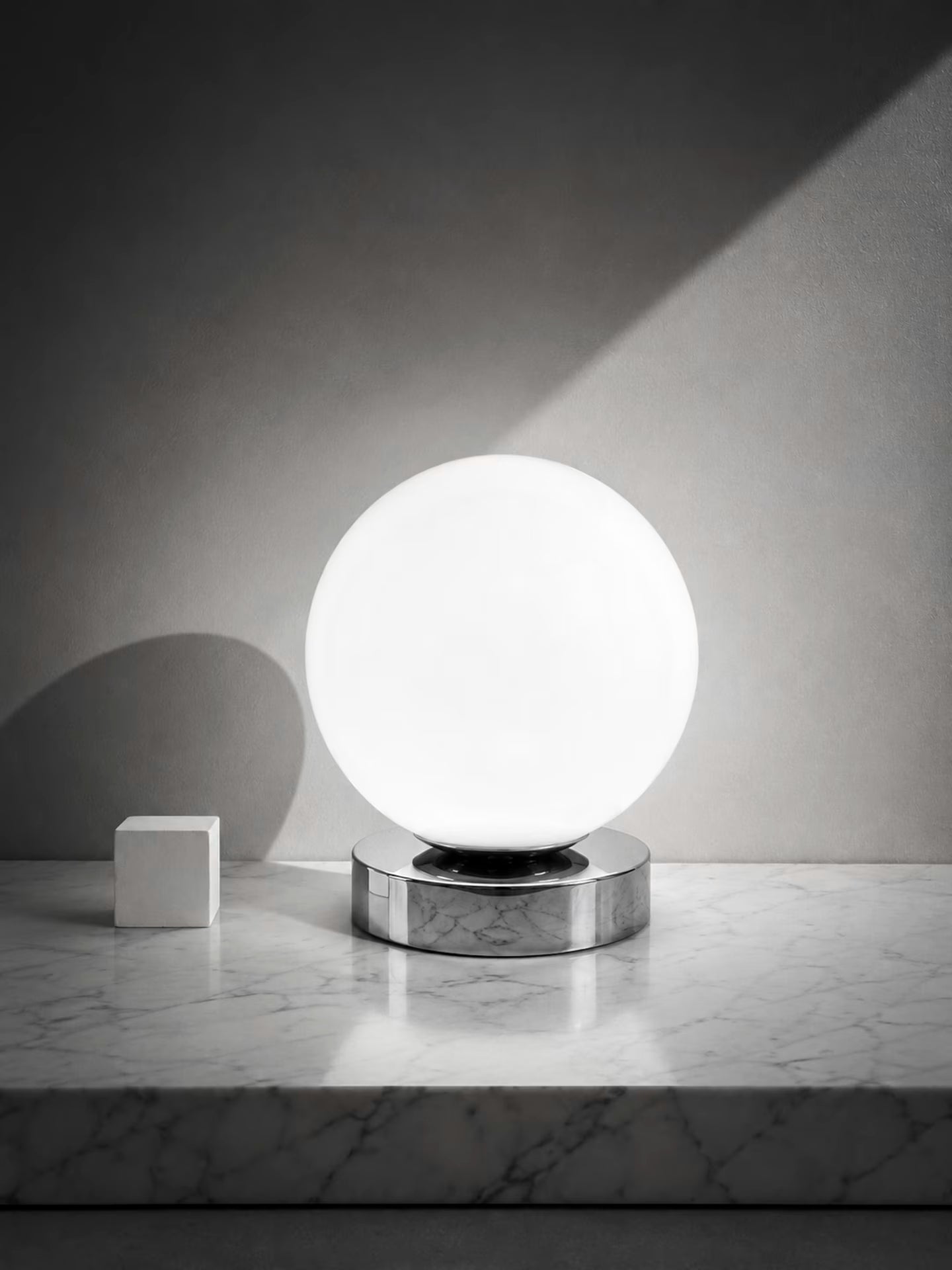 Nova Luna white glass globe table lamp on a low chrome-finish base