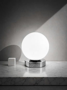 Nova Luna white glass globe table lamp on a low chrome-finish base