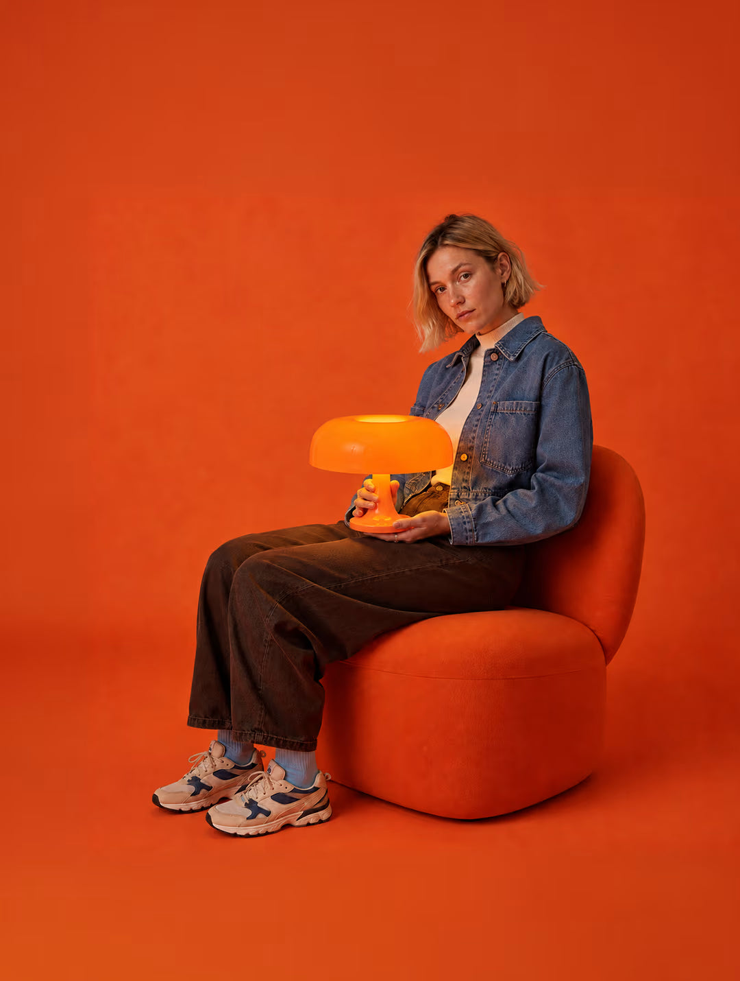 Orange Ambient Mushroom Desk Lamp styled beside a seated woman