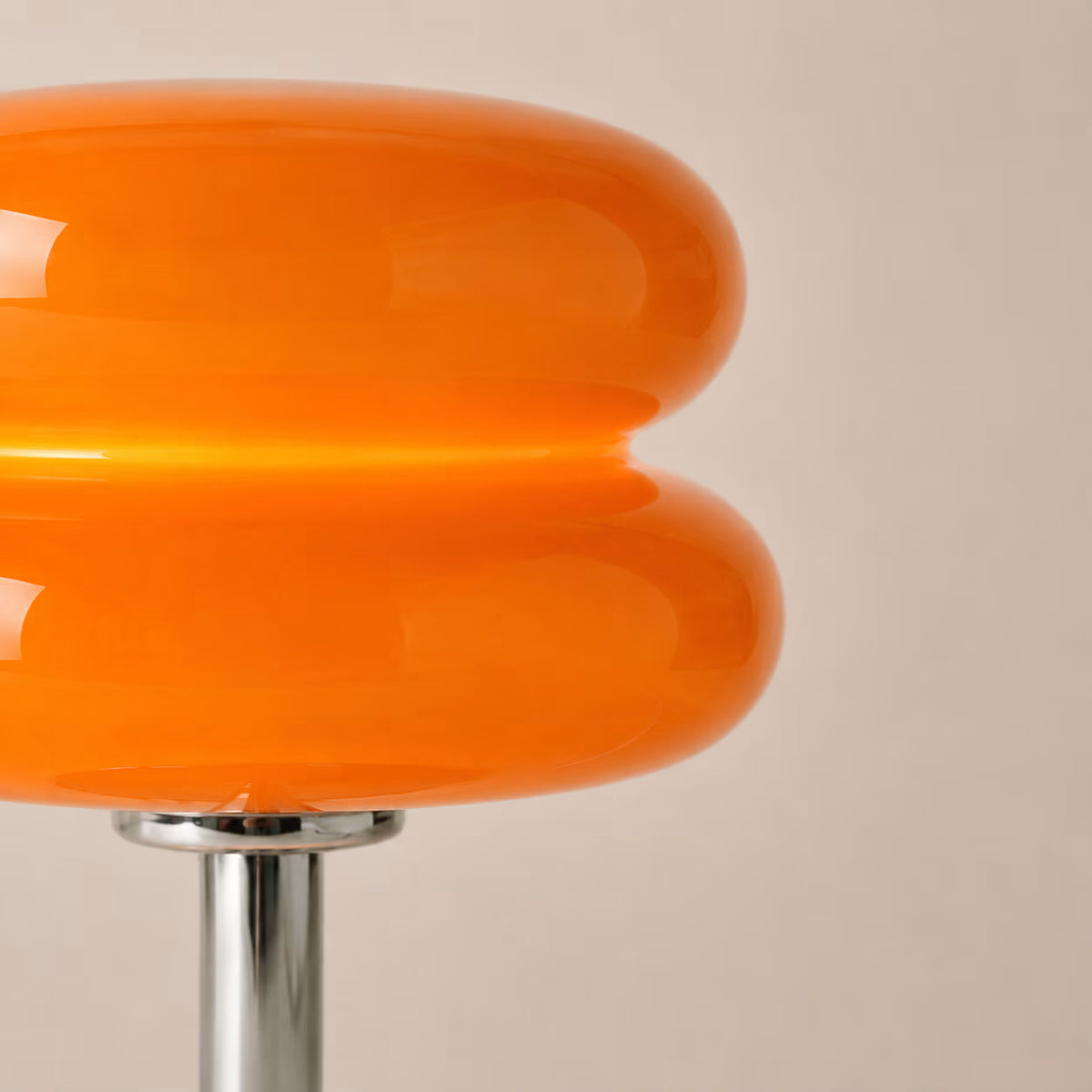 Side view of the orange Macaron glass table lamp and plated-iron base