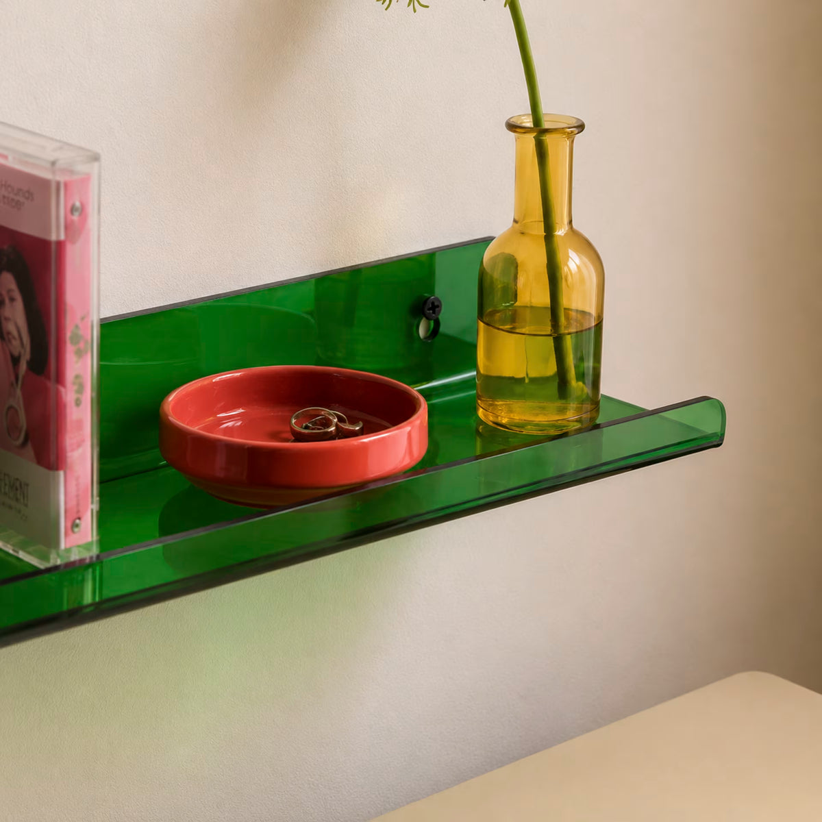 Green transparent acrylic shelf styled with a vase and decorative objects