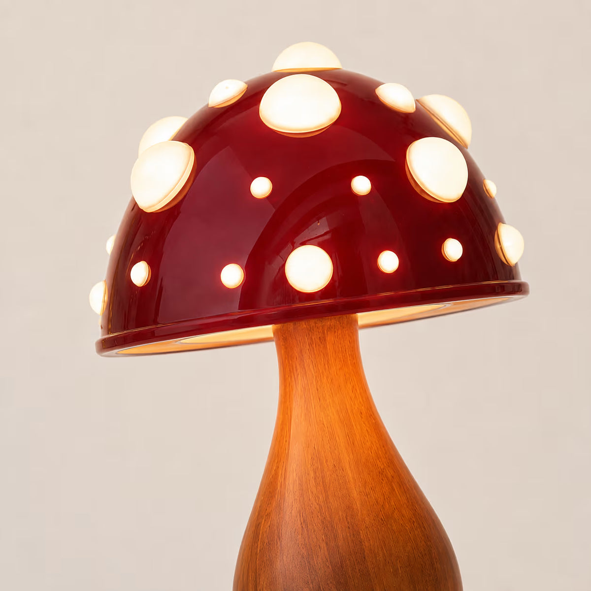 Red Shiitake mushroom lamp shown with its dome illuminated