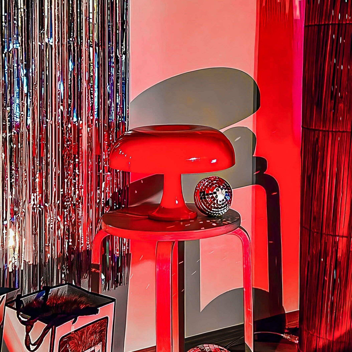 Orange mushroom desk lamp glowing on a side table beside mirrored décor